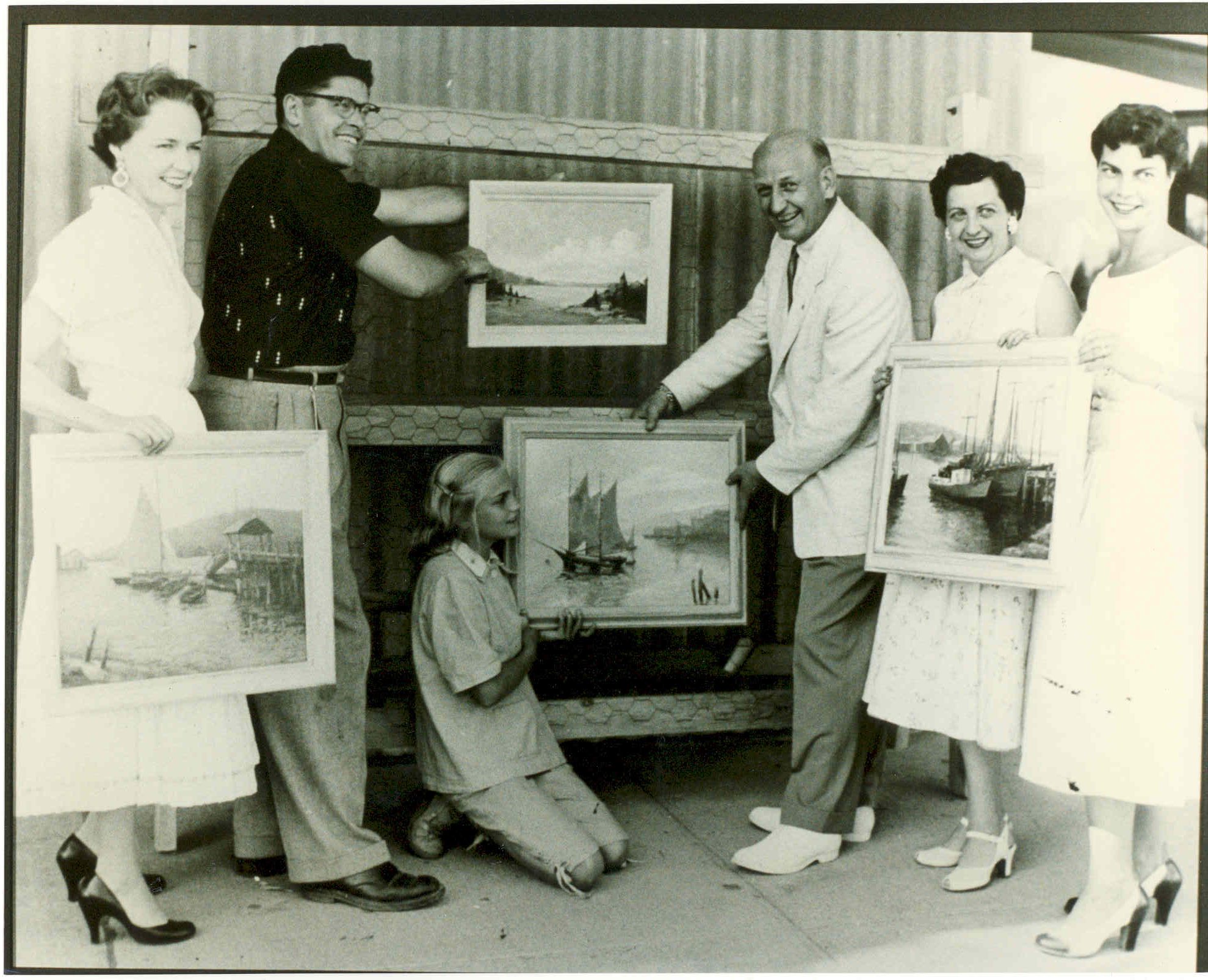 Historical image of people holding framed paintings at early Artsfair.