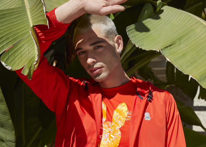 Model wearing Psycho Bunny orange jacket and t-shirt