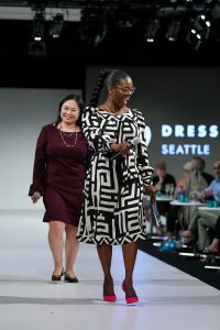 Two women walk the runway at fashion week