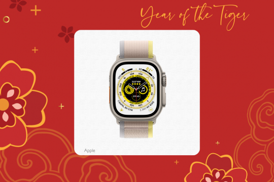 A white square frame at the center of a red floral background, with an image of a silver Apple Watch in the middle. The text at the top says Year of the Tiger and the text at the bottom says Apple.