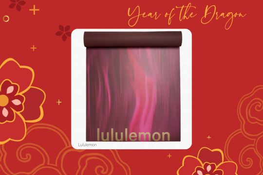 A white square frame at the center of a red floral background, with a burgundy yoga mat at the center with "lululemon" emblazed on it in gold. The words "Year of the Dragon" are at the top and "Lululemon" are at the bottom.