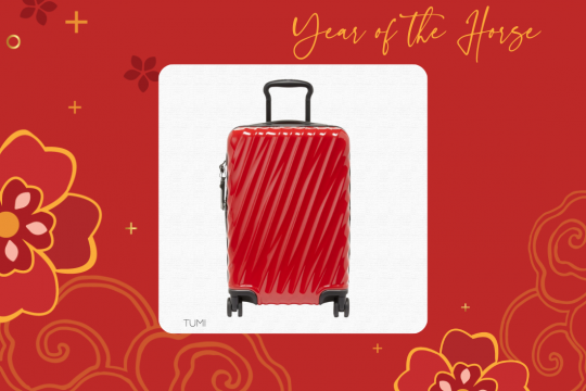 A white square frame at the center of a red floral background, with an image of a red wheeled suitcase and the words "Year of the Horse" and "TUMI"