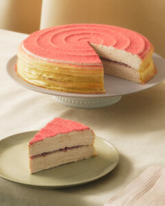 Tart, creamy, and sweet, our popular Strawberry Swirl Mille Crêpes brings together decadent strawberry-infused sponge cake, paper-thin crêpes, and strawberry pieces. Finished with an elegant swirl of strawberry pastry cream and strawberry powder.